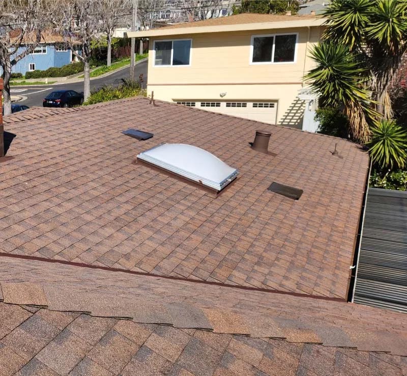 alt="Astro Roofing service van parked beside a newly installed gray asphalt shingle roof in Oakland, CA"